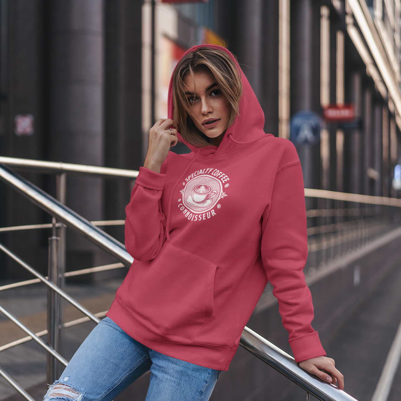 Person wearing a red Specialty Coffee Connoisseur hoodie, standing on a city street.
